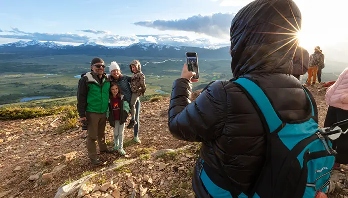 person taking photo of family while hiking